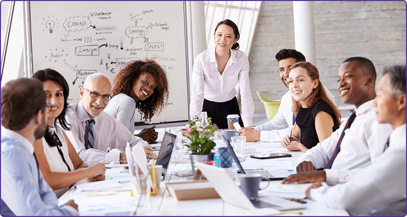 A group of people in a meeting with all people looking at a person.