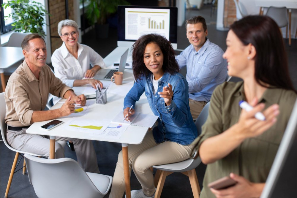 people smiling at a woman in a meeting